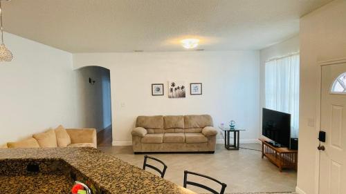 a living room with a couch and a living room with a table at Casa Flamingo in Cape Canaveral