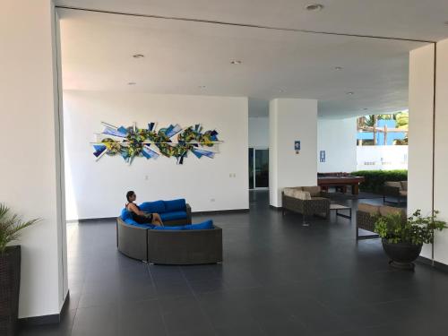 a man sitting on a couch in a lobby at Departamentos frente al mar in Tonsupa