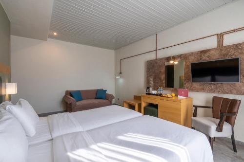 a hotel room with a white bed and a desk at Kastalia Boutique Hotel in Delfoi