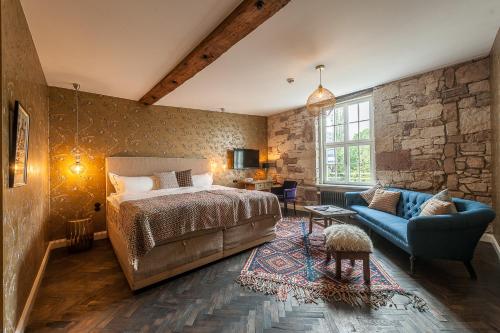 - une chambre avec un lit et un canapé bleu dans l'établissement Renthof Kassel, à Cassel