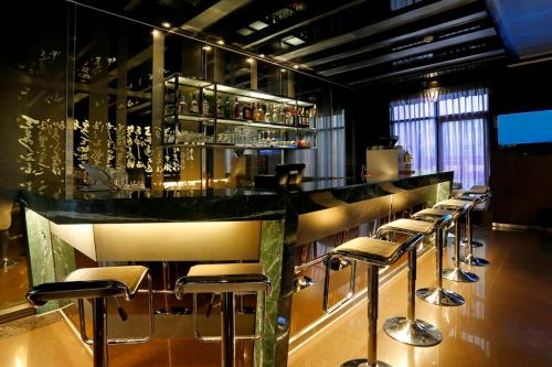 a bar with a row of stools in a restaurant at Golden Tulip - Aesthetics in Zhunan