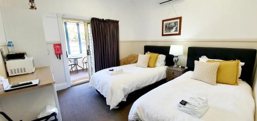 a hotel room with two beds and a balcony at Coppers Hill Private Accommodation in Gloucester