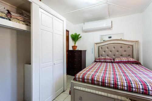 1 dormitorio con cama y armario en Moonlight Cottage en East End Village