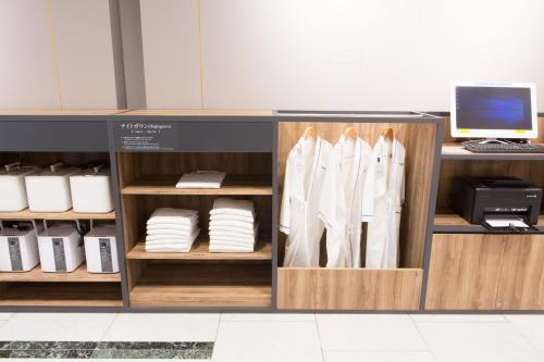 a counter with white shirts and a desk at Toyama Chitetsu Hotel in Toyama