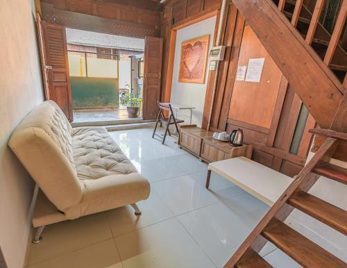 a living room with a chair and a staircase at MANDARIN LODGE by victor in Hua Hin