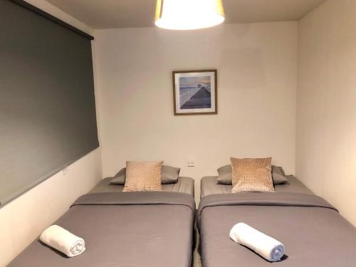 2 Betten in einem kleinen Zimmer mit einer Wand in der Unterkunft TAP Salaya in Salaya