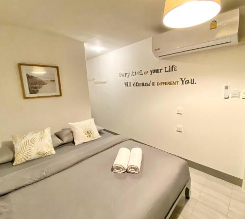 a bedroom with a bed with two shoes on it at TAP Salaya in Salaya