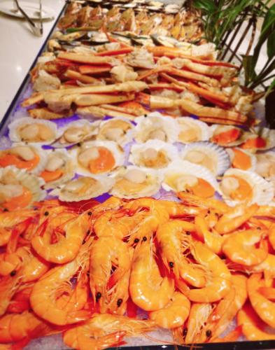 a buffet of food with oranges and other foods at Taizhou Haiyan Jinling International Hotel in Taizhou