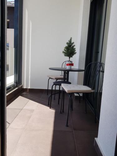 a table and chairs in a room with a potted plant at SunStone Apartment in Zlatibor