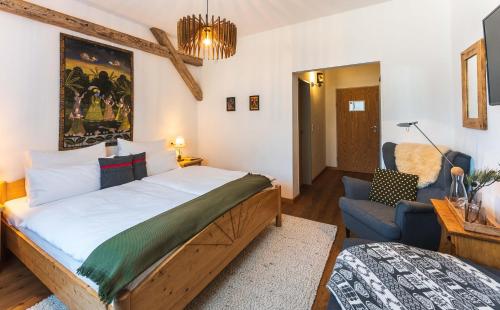 a bedroom with a large bed and a blue couch at Das Halali - dein kleines Hotel an der Zugspitze in Ehrwald