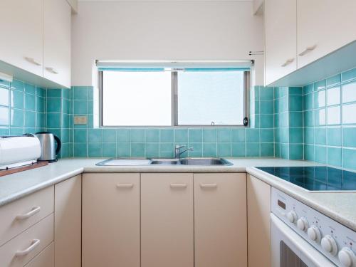 a kitchen with a sink and a window at Ocean Shores 12 Waterfront Unit with Sensational Water Views WiFI and Air Conditioning in Nelson Bay