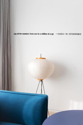 a room with a blue chair and a lamp at Stey Beijing 798 Art Zone Hotel in Beijing