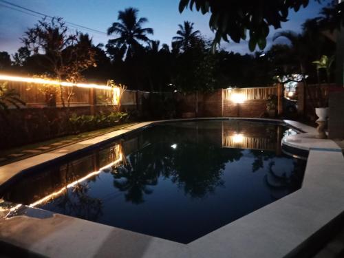 a swimming pool with lights in a backyard at night at Bello Bungalow in Batukliang