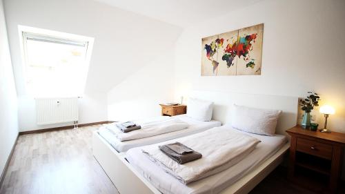two beds in a room with white walls and a window at Generous & bright flat - private Parking, daylight bathroom - by homekeepers in Zell am Main