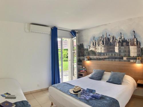 a bedroom with a bed with a painting on the wall at Logis Hôtel du Château in Tour-en-Sologne