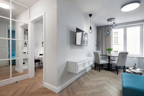 a living room with a table and a dining room at Elite Apartments Ogarna Prestige in Gdańsk