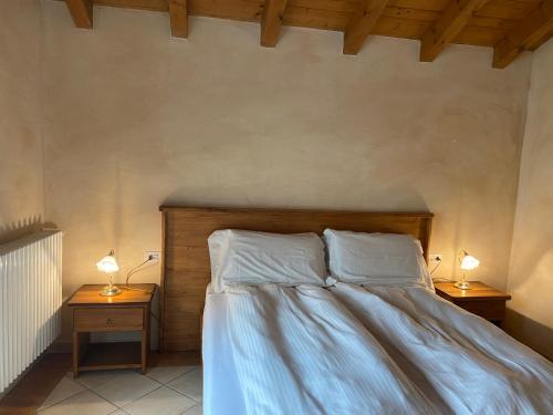 a bedroom with a bed with two lamps on tables at Garni Viggiona in Trarego