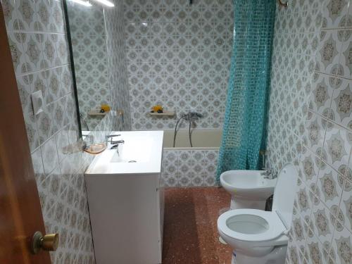 La salle de bains est pourvue d'un lavabo, de toilettes et d'un miroir. dans l'établissement Bonito apartamento en primera línea de playa, à Cala del Moral