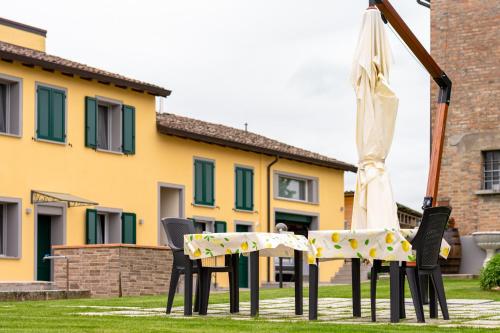 a table and chairs with an umbrella in the grass at B&b IL CERE in Alseno
