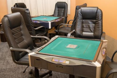 a room with four chairs and a ping pong table at Kur and Hotel Isawa in Fuefuki