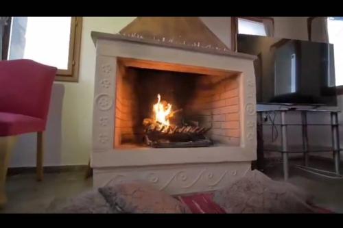a fireplace with a fire in it in a living room at Stone Villa Lagonisi in Lagonissi