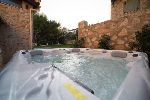 a jacuzzi tub in a yard next to a building at Stone Villa Lagonisi in Lagonissi