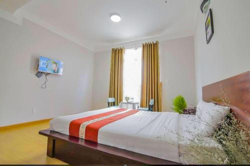 a bedroom with a large bed and a window at Jolie House in Da Lat