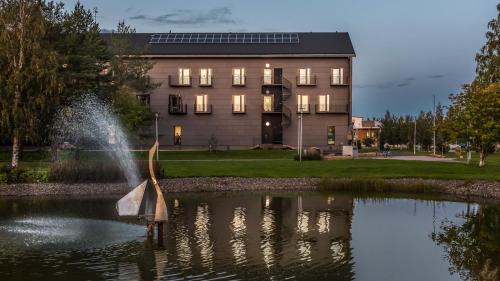 a fountain in a pond in front of a building at Park Hotel Liminka in Liminka