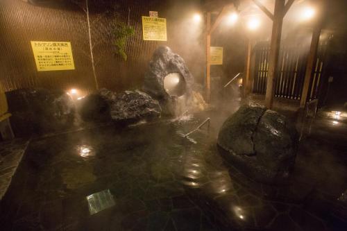 a fountain in the middle of a building at night at Kur and Hotel Shinshu in Shiojiri