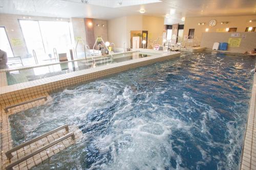 duży basen z wodą w holu w obiekcie Kur and Hotel Shinshu w mieście Shiojiri