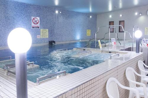 a large swimming pool in a building at Kur and Hotel Shinshu in Shiojiri