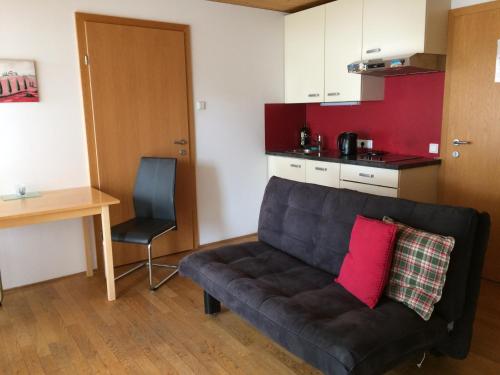 a living room with a couch and a chair at Wäldermetzge Hüttenzimmer und Wohnungen in Warth am Arlberg