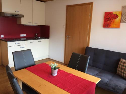 ein Esszimmer mit einem Tisch und einer Küche in der Unterkunft Wäldermetzge Hüttenzimmer und Wohnungen in Warth am Arlberg