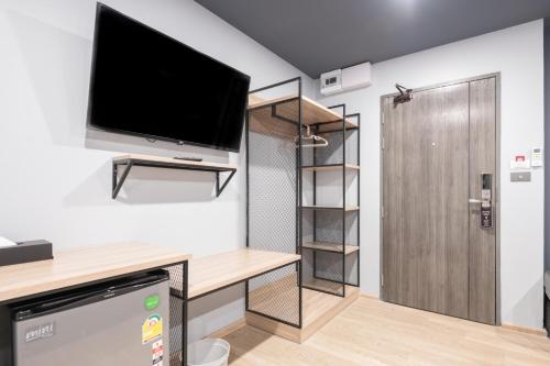 a small room with a tv and a closet at Oblique Apartment - ออฟบลิค อพาร์ทเมนท์ in Nonthaburi