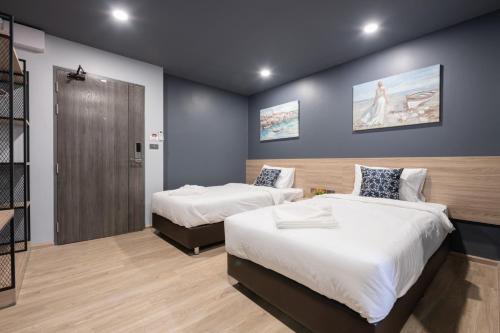 a bedroom with two beds and a closet at Oblique Apartment - ออฟบลิค อพาร์ทเมนท์ in Nonthaburi