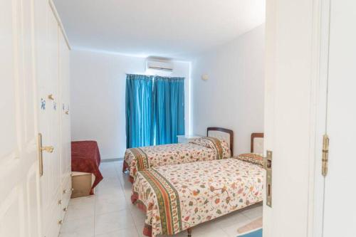 - une chambre avec 2 lits et un rideau bleu dans l'établissement St Julians' Sea Front, Spectacular View, Apartment, à San Ġiljan