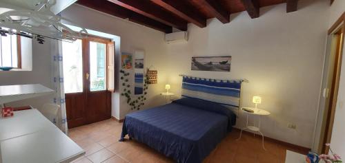 a bedroom with a blue bed and a window at Appartamento Aretusa in Syracuse