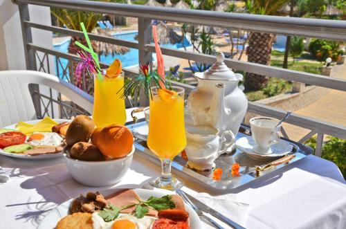 un tavolo con un piatto di cibo e bevande di Sunny Garden Hotel a Tsilivi