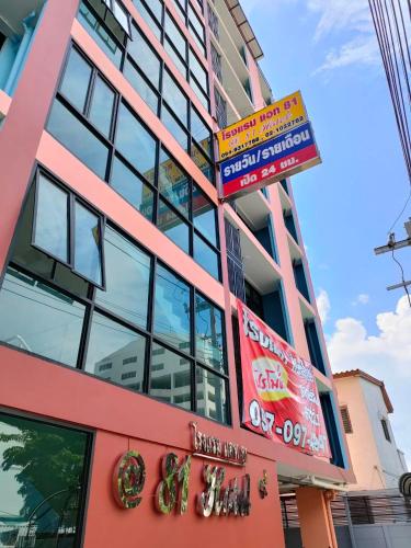 un bâtiment rouge avec des panneaux sur son côté dans l'établissement @81Hotel, à Bangkok