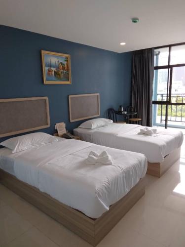 2 camas en un dormitorio con paredes azules en @81Hotel, en Bangkok