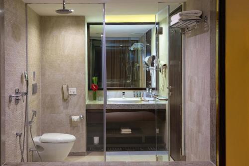 a bathroom with a toilet and a sink and a shower at Novotel Imagicaa Khopoli in Khopoli