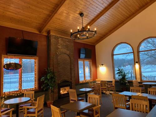 um restaurante com mesas e cadeiras e uma lareira em Jolly Roger Inn & Resort em Otter Lake