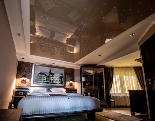 a bedroom with a large bed with a star ceiling at Hotel Novotheos in Oradea