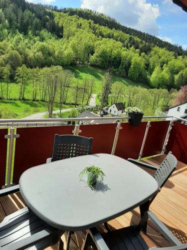 a table on a balcony with a view of a mountain at Fewo Zum Sonnenschein in Simmerath