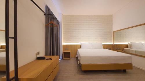 a hotel room with two beds and a mirror at Ra Inn Kemang in Jakarta