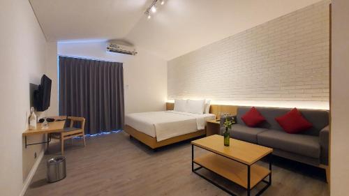 ジャカルタにあるRa Inn Kemangのベッドとソファ付きのホテルルーム
