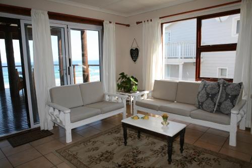 a living room with two couches and a coffee table at Pienaars Guesthouse in Groot Brak Rivier