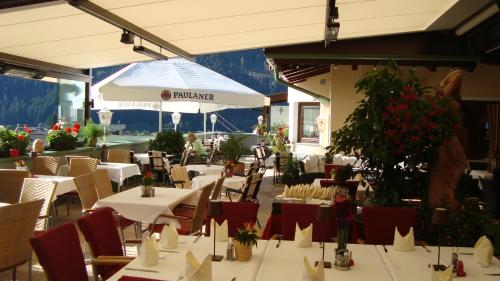 a restaurant with tables and chairs and an umbrella at Hotel Ländenhof Superior in Mayrhofen