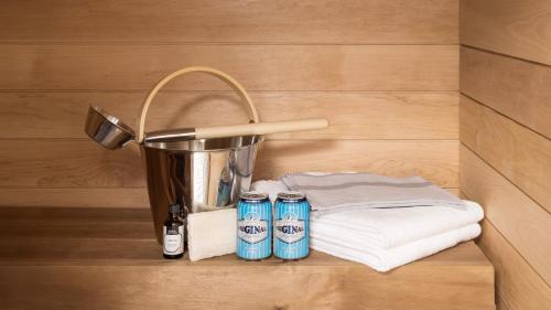 a sink with three cans of water and towels at Bob W City Centre in Helsinki