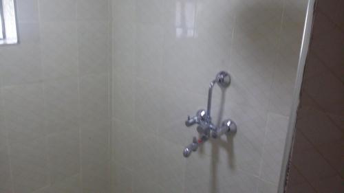 a shower stall with a faucet on a wall at Maili Saba Camp in Nakuru
